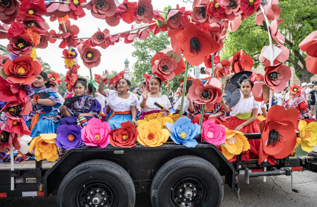 Members of the Georgetown ISD Ballet Folklorico troupe ride  in their float during  the Red Poppy Festival parade on Saturday, April 25, 2026.   Photo by  Andy Sharp.  
