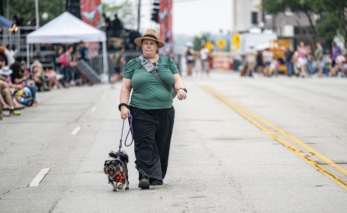 Cynthia Lorentz strolls along Austin Avenue with her dog Gazali as they wait for the start of the Red Poppy Festival parade on Saturday, April 25, 2026.   Photo by  Andy Sharp.