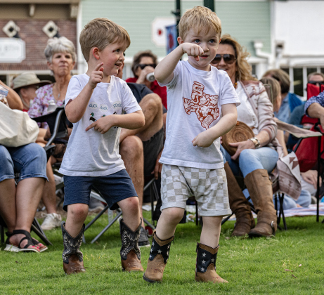 4-year-old Holton Henton, left, and his brother Jackson, 3, right, enjoyed dancing to  the music of Supernatural ATX, a Santana Tribute Band, during the first First Friday free concert of the year on the courthouse lawn on Friday, April 3, 2026.  The event was hosted by the Georgetown Beard Club.   Photo by  Andy Sharp.