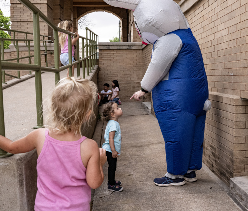 2-year-old Sloan Denemarks was enthralled with a gigantic Easter Bunny while her family listened to  the music of Supernatural ATX, a Santana Tribute Band, during the first First Friday free concert of the year on the courthouse lawn on Friday, April 3, 2026.  The event was hosted by the Georgetown Beard Club.   Photo by  Andy Sharp.