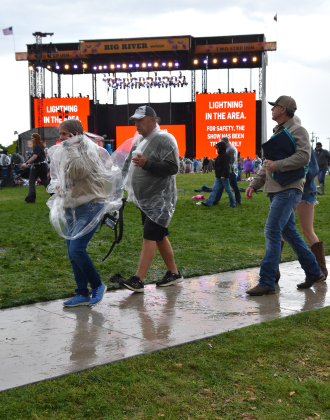 Festival goers bear the rain in ponchos as shows were temporarily delayed in the afternoon of Saturday, April 18, due to lightning in the area. The major acts on Saturday, Kaitlin Butts’ Yee-Hoedown, Shenandoah, Goo Goo Dolls, Wyatt Flores and Tracy Lawrence and Brooks & Dunn were cancelled due to the forecast. (Photos by Kaitlyn Wilkes)