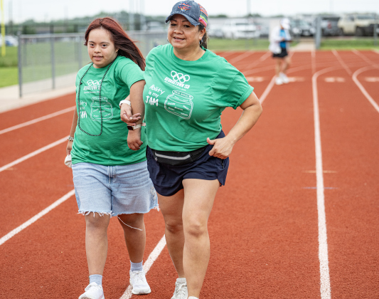 East View High student Emerson Huerta gets a helping hand from her teacher Dora Rodriguez as she nears the finish of her 100-meter run during the Georgetown ISD Special Olympics on Tuesday, May 5, 2026.