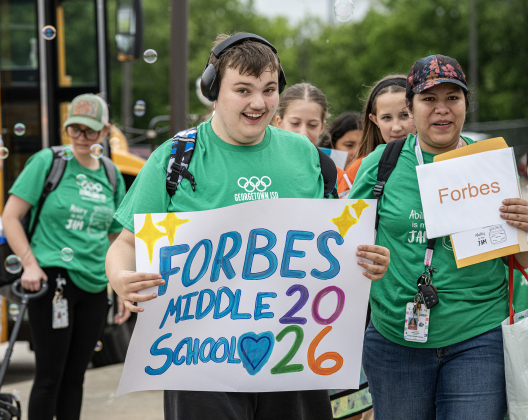 Forbes Middle School student J.C. Cornitius, 14, joined by his teacher Carolina Banuelos, right,   is welcomed with a spray of bubbles from well-wishers as he and his team arrive for the Georgetown ISD Special Olympics on Tuesday, May 5, 2026.  The annual event, held at the Georgetown ISD Athletic Complex, continued on Wednesday.     Photo by Andy Sharp.