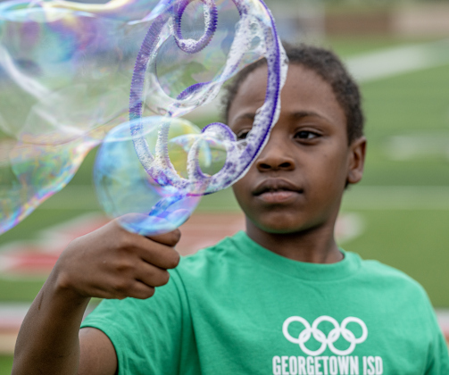 Purl Elementary student Jevon Taylor, 11, takes some time away from competition to create very large bubbles in the Activity Village area during the Georgetown ISD Special Olympics on Tuesday, May 5, 2026.