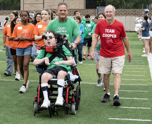 Georgetown High School student Cooper Harris is accompanied by his father Tol Harris and their friend Mike Melton (red shirt at right), as they participate the opening ceremony during  the Georgetown ISD Special Olympics on Tuesday, May 5, 2026.