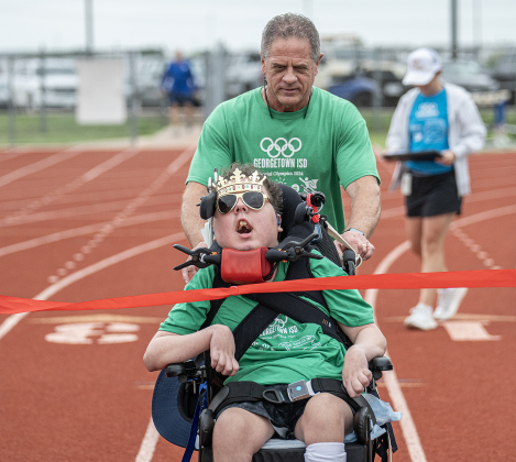 Georgetown High School student Cooper Harris is joined by his dad Tol Harris as he nears the finish line of a track event during  the Georgetown ISD Special Olympics on Tuesday, May 5, 2026.