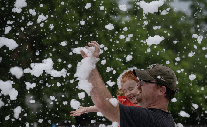Nathan Moore and his daughter Irene, 3, enjoy spending time with in the Foam Party during the 47th Annual Lakefest in downtown Granger on Friday, May 8, 2026.    Photo by Andy Sharp.