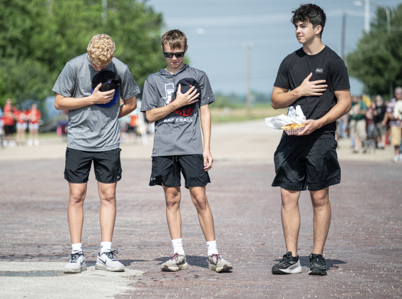 Granger ISD baseball team members (left to right) Cohen Repa, 14, Ty Randig, 14, and Tanner Brett, 15, pause for the posting of the colors before the start of the parade along West Davilla Street during the 47th Annual Granger Lakefest on Saturday, May 9, 2026.   Photo by Andy Sharp.