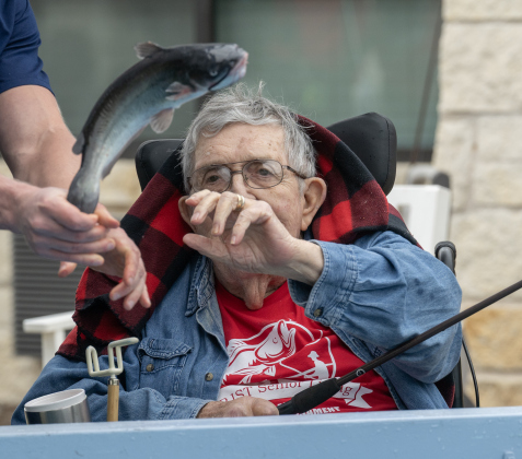Joe Vrabel reaches out to touch one of fish he  caught during the 23rd Annual SPJST Senior Living Fishing  Tournament on Thursday, May 7, 2026. Senior Living residents fished for 600 pounds of Channel Catfish during the two-day event which continued on Friday.  Residents and staff were treated to a fish fry to celebrate the event.  The fish were provided by Larry’s Fish Farm in Giddings.   Photo by Andy Sharp.