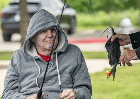 David Kuemeel admires a fish he caught during the 23rd Annual SPJST Senior Living Fishing  Tournament on Thursday, May 7, 2026. Senior Living residents fished for 600 pounds of Channel Catfish during the two-day event which continued on Friday.  Residents and staff were treated to a fish fry to celebrate the event.  The fish were provided by Larry’s Fish Farm in Giddings.   Photo by Andy Sharp.