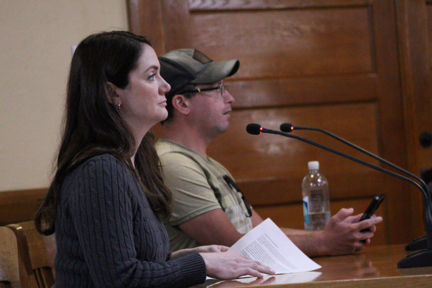 Jenna Lewis (front), who was a former attorney, speaks in opposition of the Jail and Justice Center property, while John Gamez (back), speaks in favor of the location, during the May 19 Commissioners Court meeting. Photo by Nalani Nuylan.