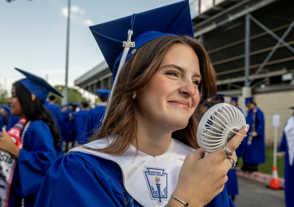 Gabri Alvarez cools off with a small fan prior to going onto the field with her classmates during the 2026 Georgetown High School commencement, held Friday, May 22, 2026 at Birkelbach Stadium.  484 students received their diplomas on this evening.     Photo by Andy Sharp.
