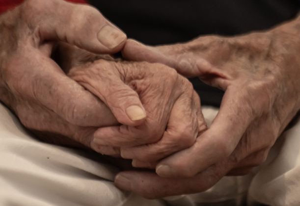 Cliff McCrummen, a World War II (Navy) veteran who will be 100-years-old on June 23rd, holds the hand of his wife Myrna  during the Memorial Day ceremony held in Sun City on Monday, May 25, 2026. Photo by Andy Sharp.