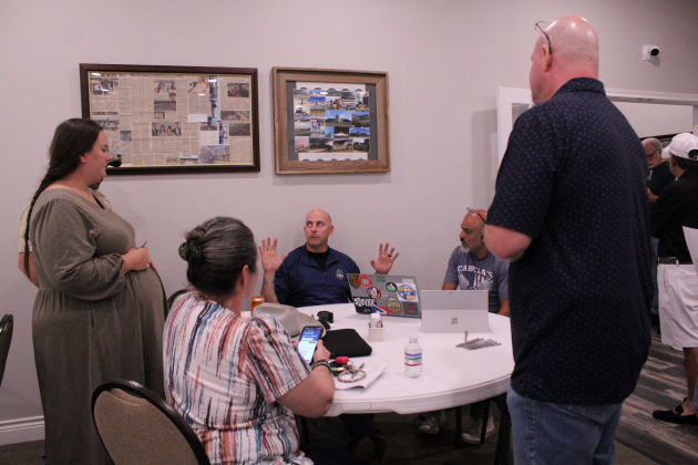 Salado resident Jaay Bradley (center), who is one of the event organizers, helps a group of neighbors file paperwork to interview and protest the transmission lines. Photo by Nalani Nuylan.