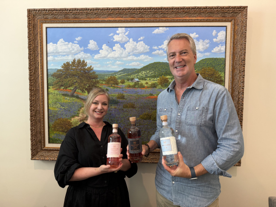 Jennifer Swanson standing next to David Kerston, the president of Waterloo Gin, holding the three flavors. Photo by Abbey Archer