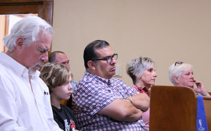 Florence residents line the pews as they wait to speak against an incoming 750-home subdivision during public comment at the June 9 Williamson County Commissioners Court meeting. From left: Howard Creasy, Frank Elverado (center), Melissa Rosenbusch-Spicer and Cristy Daniell. Photo by Nalani Nuylan.