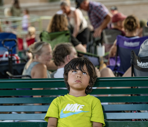6-year-old Joshua Scott was glad to find a shady spot to hold off the heat while his family enjoyed music played by  Vinyl Countdown G/ATX! during the free First Friday concert held on the Williamson County Courthouse lawn on Friday, June 12, 2026.  The concerts, hosted by the Georgetown Beard Club, are generally on the first Friday of the month, but this one was postponed because of rain last week.     Photo by Andy Sharp