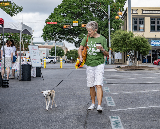 Paula Fouchek and her dog Jack stroll along 8th Street during Market Days on Saturday, July 11, 2026.  Market Days  is held on the second Saturday  of the month in downtown Georgetown.   Photo by Andy Sharp