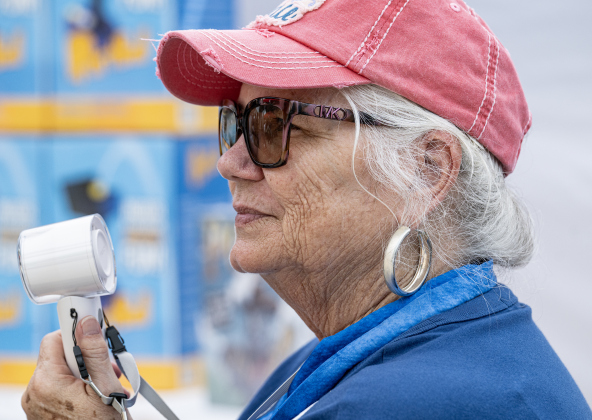 Vendor Carla Ricks cools off with a portable fan along Main Street during Market Days on Saturday, July 11, 2026.  Market Days  is held on the second Saturday  of the month in downtown Georgetown.   Photo by Andy Sharp