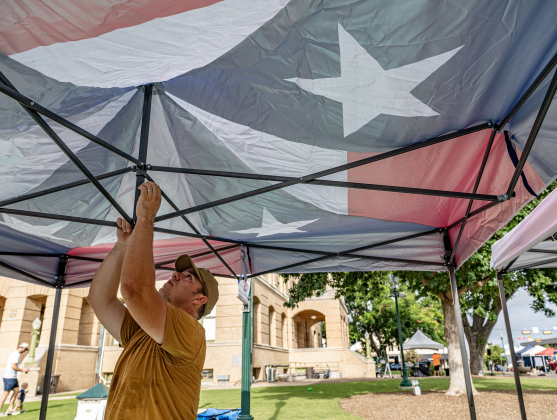 Vendor Pablo Hernandez sets up his Texas-themed cover along Main Street during Market Days on Saturday, July 11, 2026.  Market Days  is held on the second Saturday  of the month in downtown Georgetown.   Photo by Andy Sharp