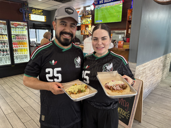 Urban Taco owners David and Erika Mata hold tacos in front of their sports bar. Photo by Abbey Archer