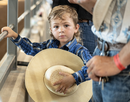 4-year-old Keegan Dalusto, a Mutton Bustin’ participant, takes off his hat as the American flag is taken through the arena  during the 3rd Annual Bill Pickett Youth Rodeo, held at the Williamson County Expo Center on Saturday, June 20, 2026.  Contestants can be no older than 18 to participate.     Photo by Andy Sharp