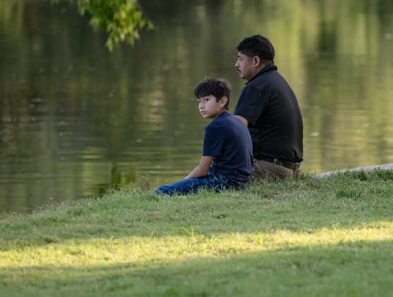 Sullivan Monte and his son Adino, 11, spend quiet time together near  the San Gabriel River at San Gabriel Park on Monday, June 22, 2026, the first day of summer.  Temperatures reached into the mid-upper 90s on this day.    Photo by Andy Sharp