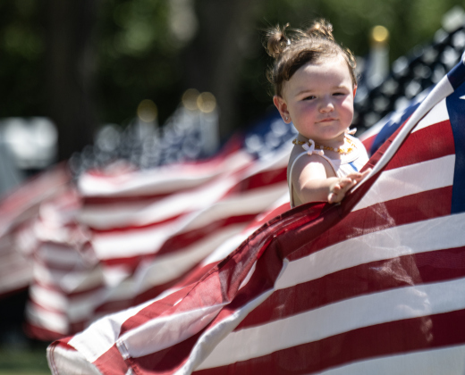 18-month-old Addison Gonzalez enjoyed being among the American flags displayed by the Rotary Club of Georgetown during the Sertoma Club 4th of July celebration at San Gabriel Park  on Saturday, July 4, 2026.   Photo by Andy Sharp