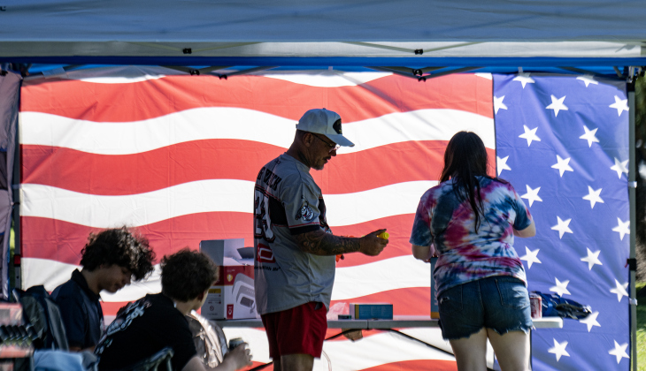 John Meacham, standing left, was joined by his daughter Avah, 16, right, and other members of their family, enjoying a patriotic flag-inspired cover next to the river  during the Sertoma Club 4th of July celebration at San Gabriel Park  on Saturday, July 4, 2026.   Photo by Andy Sharp