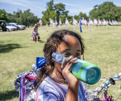 8-year-old Camilla Warwick cools off and hydrates after participating in the Sertoma Club’s Hometown Parade through San Gabriel Park during the Sertoma Club 4th of July celebration on Saturday, July 4, 2026.   Photo by Andy Sharp