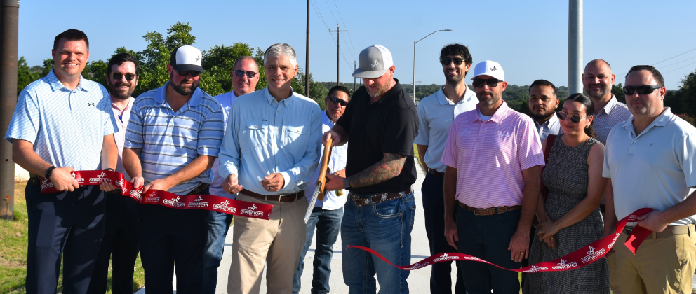 Members from the City of Georgetown, Kimley-Horn Engineers and Jordan Foster Construction gather on July 22 to cut the ribbon for the completion of phase 1 of DB Wood Road updates. (Photo by Kaitlyn Wilkes)