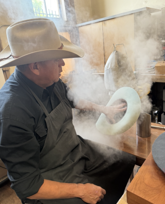  Mr. Funmaker uses a hatsteamer and handshapes the brim and crown into its final shape. Photo by Abbey Archer