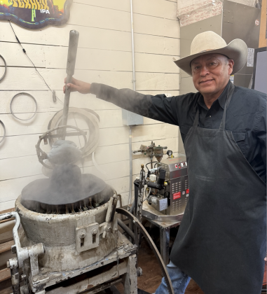 Nathaniel Funmaker using the 100-year-old blocking machine that steams, stretches and molds the felt over a wooden hat block. Photos by Abbey Archer