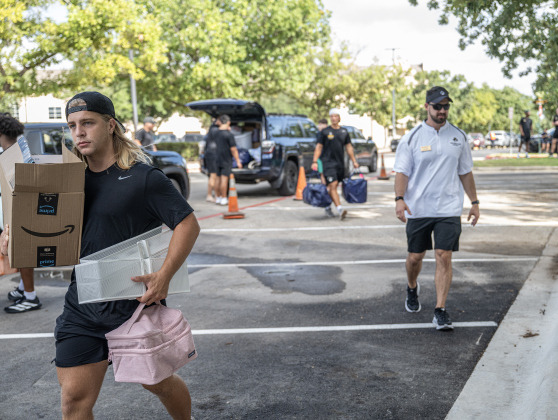 Jackson Gallagher, a freshman football team member from College Station, helps other freshmen move  into Jessie Daniel Ames Hall during freshmen move-in day at Southwestern University on Saturday, August 15, 2026.   The school's football team was in place to help parents and new students move into their rooms.    Jessie Daniel Ames Hall opened to students in January.