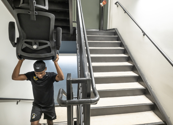 Christian Murray, a sophomore member of the football team, totes a chair for a new student  into Jessie Daniel Ames Hall during freshmen move-in day at Southwestern University on Saturday, August 15, 2026.
