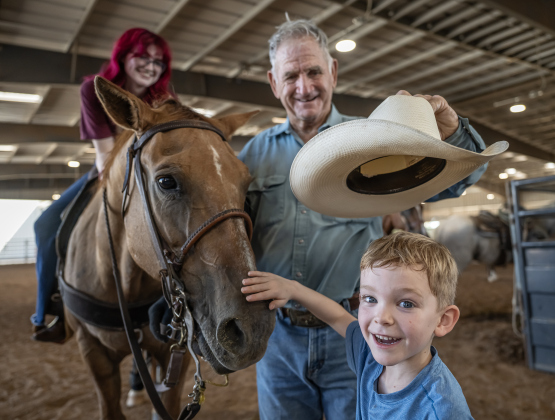 Ed Denison of Hockley, Texas, who will be 80 in October introduces his horse called Hombre to his grandson, 8-year-old Levi Bentley and family friend McKenna Degarmo, 17, (sitting on Hombre) during the Texas Senior Pro Rodeo Association’s Rodeo held Sunday, August 16, 2026  at the Williamson County Expo Center. Denison has been competing in rodeos for decades.  Texas Senior Rodeo Association competitors must be at least 40-years-old to compete.  Many are in their 70s and 80s. Photo by Andy Sharp 