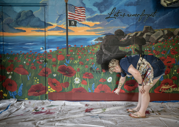 Artist Shelby Gage puts finishing touches on a 7’x25’ mural she created for the Msg. Ben D. Snowden Post 8587 on Friday, August 14, 2026.