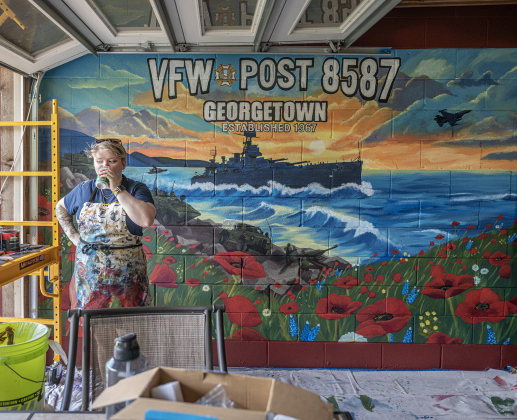 Shelby Gage stands with her 7’x25’ mural she created for the Msg. Ben D. Snowden Post 8587 on Friday, August 14, 2026.