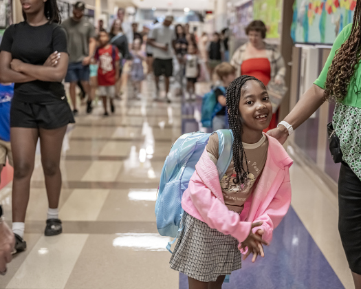 First grader Sevyn Wilkerson heads to her classroom after visiting with principal Charlotte Young  on Wednesday, August 19, 2026,  the first day of classes at George Washington Carver Elementary School.