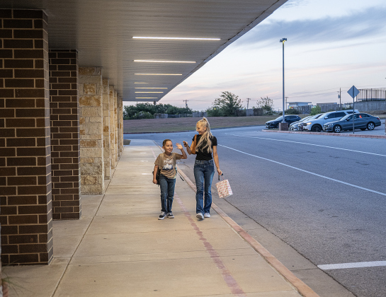 Amanda Bueno walks with her son Roman, 8, on Wednesday, August 19, 2026,  the first day of classes at George Washington Carver Elementary School.