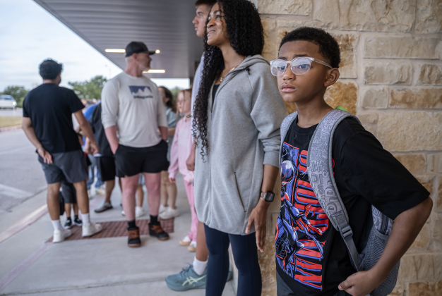10-year-old 5th grader Grandtham Hunt waits for school entry with his mom Beth Hunt  on Wednesday, August 19, 2026,  the first day of classes at George Washington Carver Elementary School.  Carver begins the school year with 672 students.