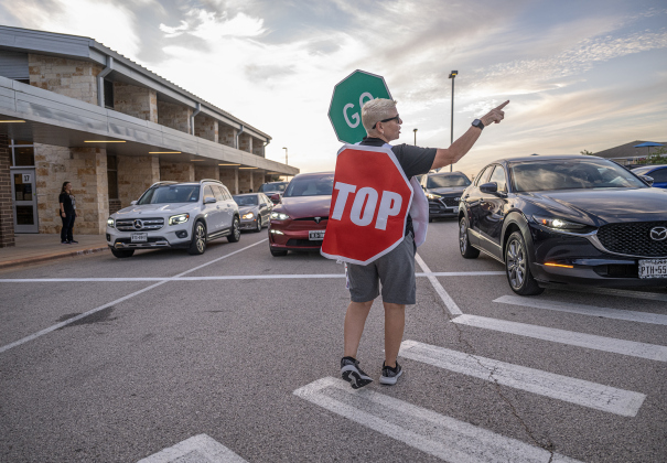 Physical education instructor Amber Sladecek helps direct incoming traffic on Wednesday, August 19, 2026,  the first day of classes at George Washington Carver Elementary School.