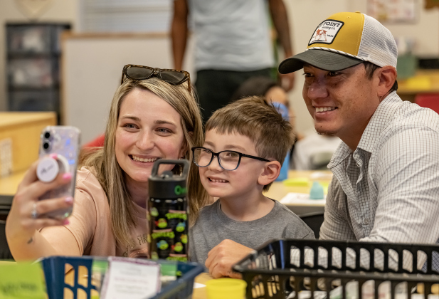 Emily and Sean Arciniaga take photos with their kindergartener son Owen, 5, on Wednesday, August 19, 2026,  the first day of classes at George Washington Carver Elementary School.