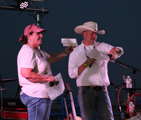 Susan Gregurek, Jarrell Community Library and Resource Center director (left), and County Judge Steve Snell (right), announce the raffel prize winners between the musical acts. Photo by Nalani Nuylan.