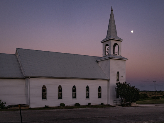 A Waxing Gibbous moon, at 94.2 % visibility, shines over Saint Peter’s Church of Coupland on Sunday, July 26, 2026.    Photo by Andy Sharp