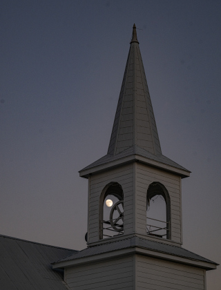 A Waxing Gibbous moon, at 94.2 % visibility, shines over Saint Peter’s Church of Coupland on Sunday, July 26, 2026.    Photo by Andy Sharp