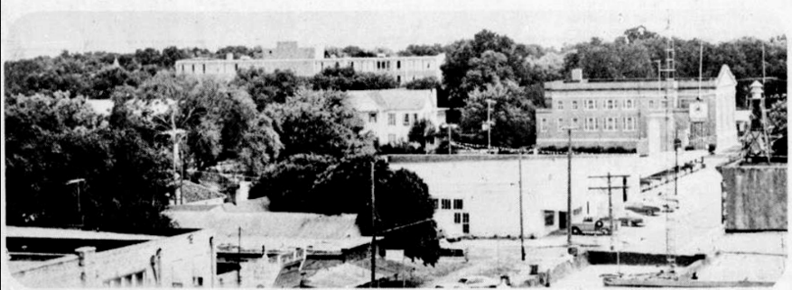 August 29, 1976: Looking out toward the Wesleyan and the First Baptist Church from the courthouse roof affords a tree-top scenario of Georgetown. The photo shows the corner of Main Street at Ninth Street (before the Heritage Church was moved there), and also includes the Compton Motors car lot (which is now the “Red Poppy” parking lot).