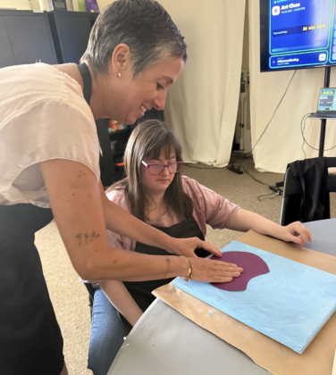 Executive Director Ivonne Rodriguez assisting Kendall Mecey in beginning the fruit-stamping bouquet art project.