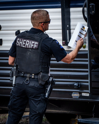 A deputy from the Williamson County Sheriff’s Office distributes flood evacuation flyers to residents in an RV park, October 1. Photo courtesy of the Williamson County Sheriff’s Office