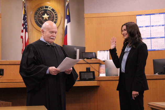 Camryn Whitman takes the oath to become an Assistant District Attorney for Williamson County on Friday, October 16, in the 368th District courtroom, where her grandfather, the late Judge Burt Carnes, presided. Judge Billy Ray Stubblefield administered the oath. Photo by Nalani Nuylan.